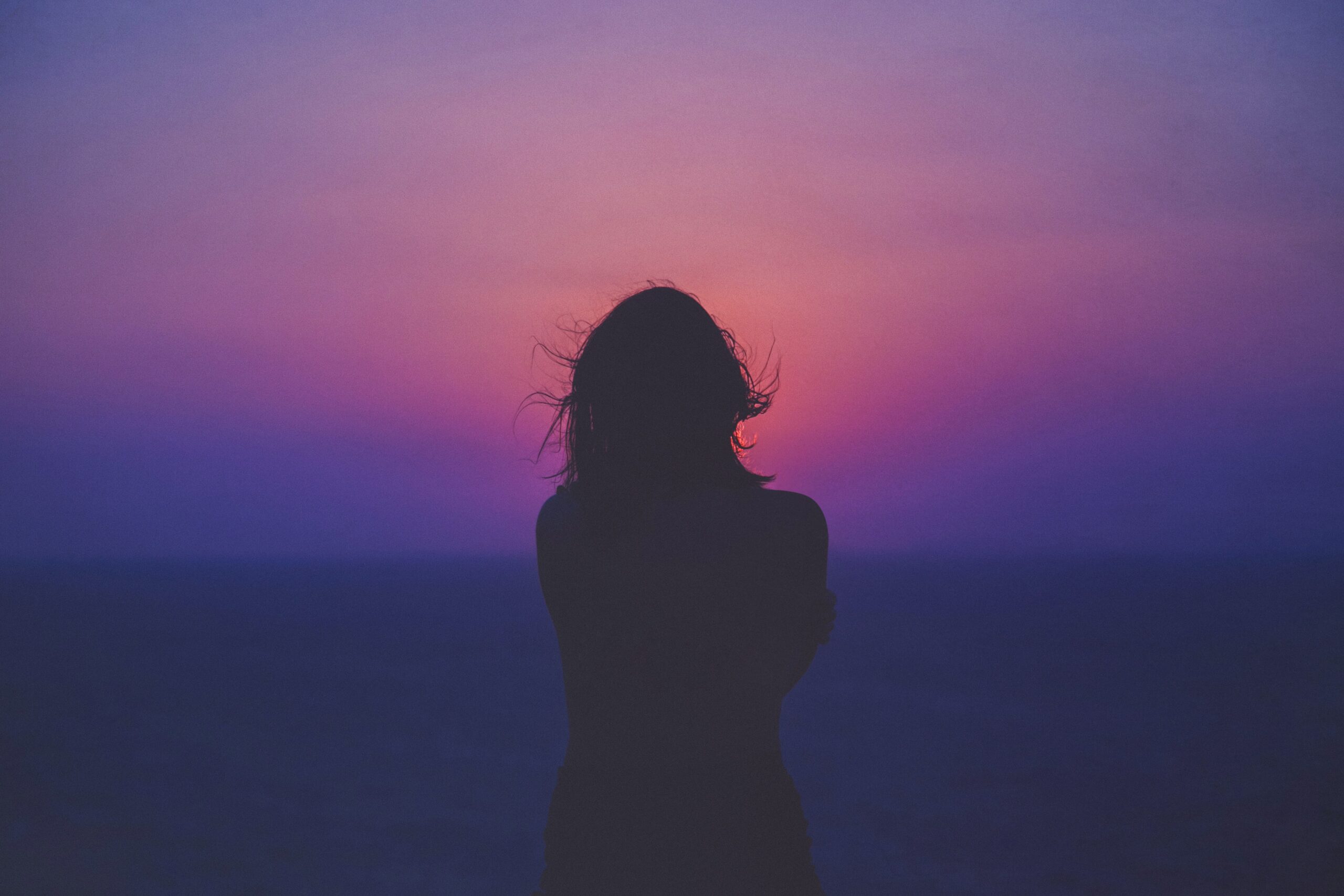 back of a person watching a colorful sunset