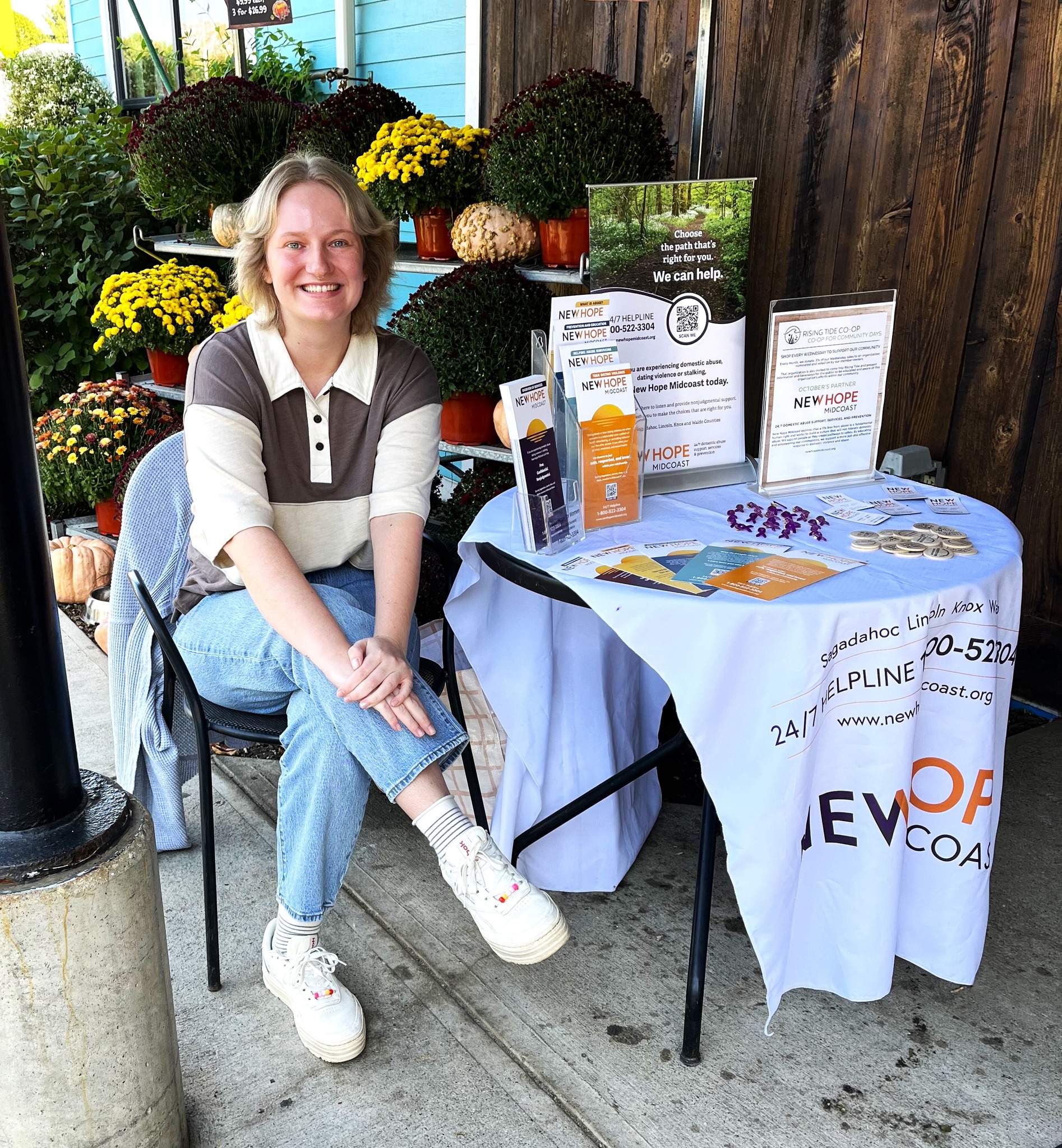 New Hope staff, Sabrina, tables outside the Rising Tide Co-op during Domestic Violence Awareness Week
