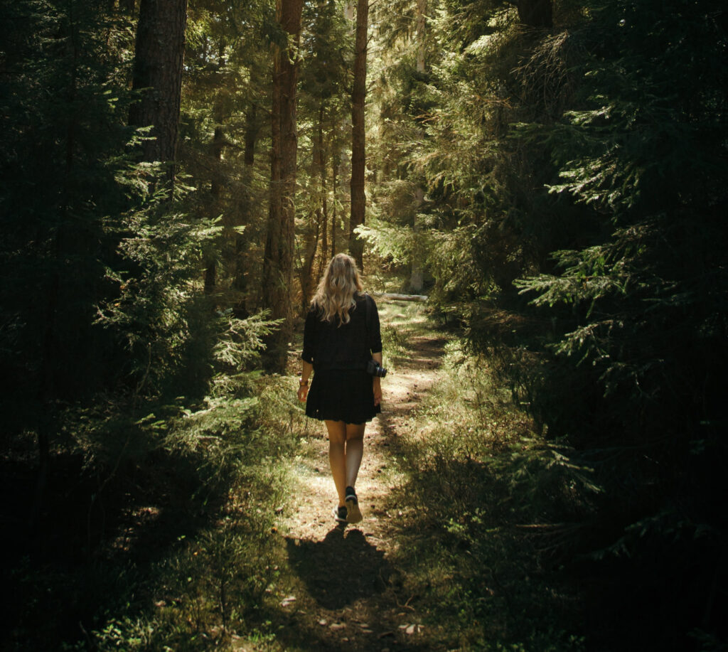 girl walking among trees