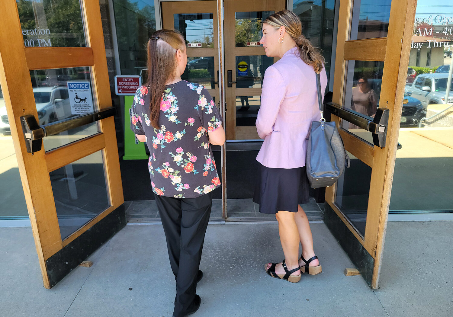 Legal advocate and client walking into a building.