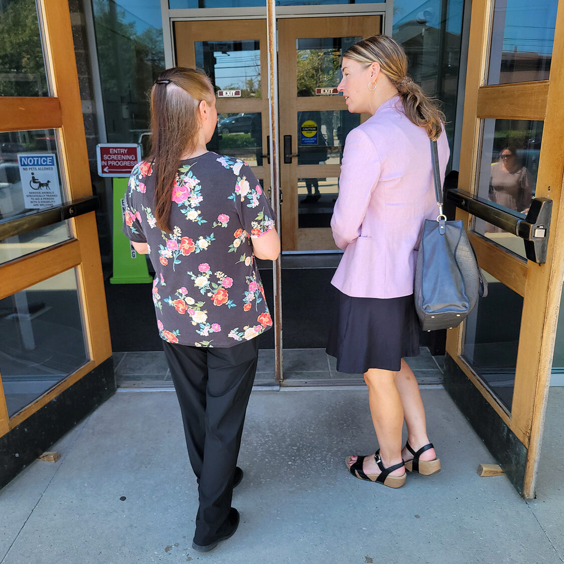 Legal advocate and client walking into a building.