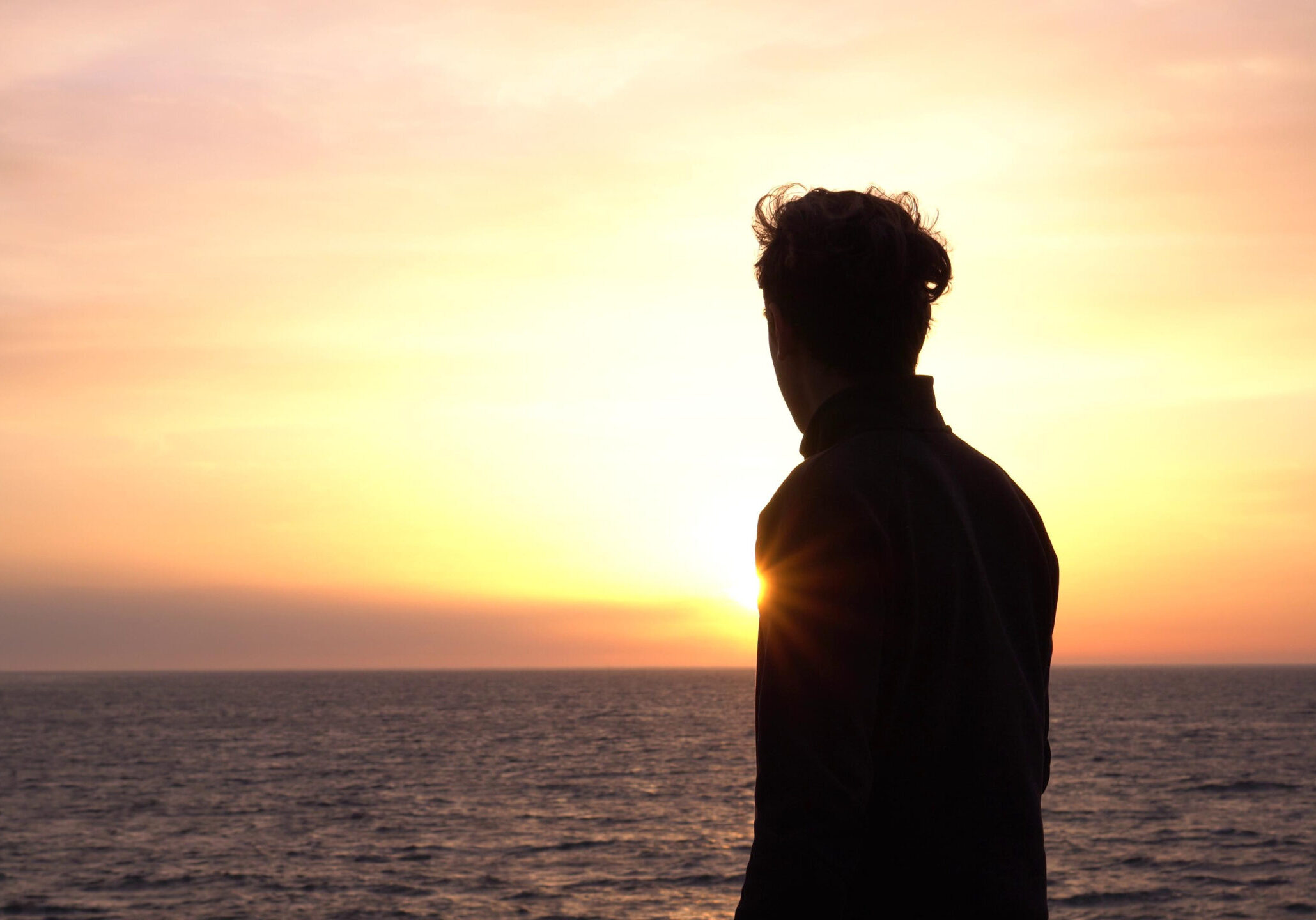 Man looks thoughtfully at the ocean